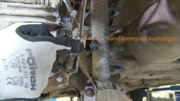 Entfernen Sie den Seilzug aus der Halterung. Aushängen des Handbremsseils am Bremssattel
