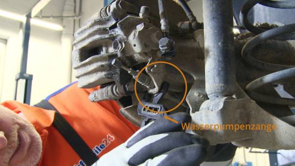 Eine Wasserpumpenzange hilft, das Handbremsseil durch die Führung zu ziehen. Handbremsseil mit Wasserpumpenzange entfernen