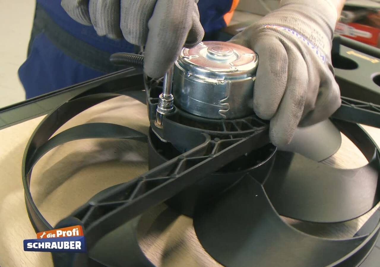 Schrauben Sie den Halter auf den neuen Lüftermotor. neuer Kühlerlüfter
