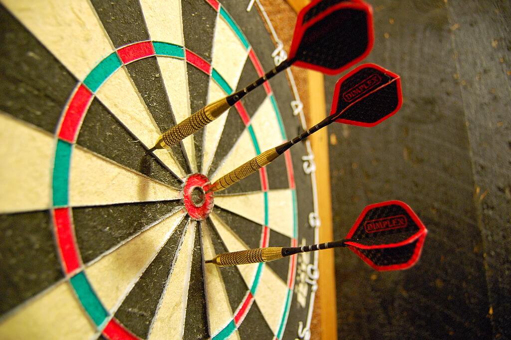 eine Dartscheibe mit steckenden Darts